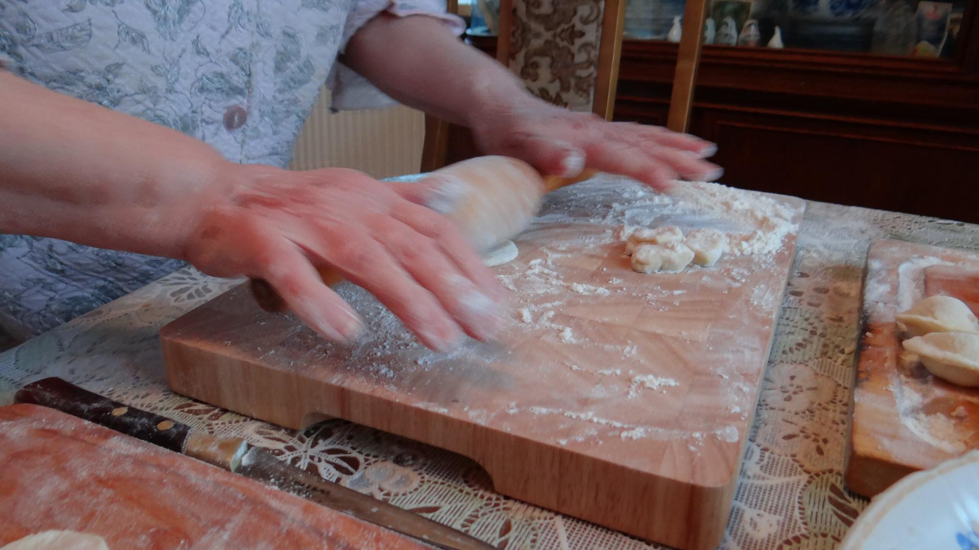 Mani che impastano su tagliere di legno